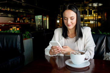 Young beautiful woman using smart phone for business, online shopping, transfer money, financial, internet banking. in coffee shop cafe