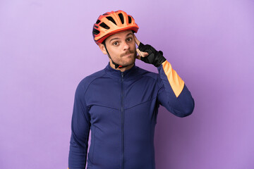 Young Brazilian cyclist man isolated on purple background thinking an idea - obrazy, fototapety, plakaty