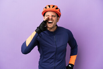 Young Brazilian cyclist man isolated on purple background shouting with mouth wide open - obrazy, fototapety, plakaty