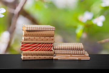 Stack of books on wooden table against blurred background