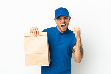 Brazilian taking a bag of takeaway food isolated on white background celebrating a victory in winner position