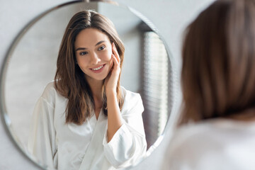 Self-Care Concept. Young Attractive Woman Looking At Mirror In Bathroom