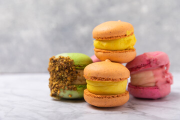Fototapeta premium Tasty macarons on a marble background. colorful almond berry cookies.Culinary and cooking concept.Side view.Copy space.Place for text