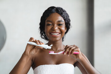 Smiling african american lady with toothbrush and toothpaste