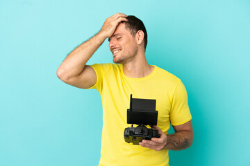 Brazilian man holding a drone remote control over isolated blue background has realized something and intending the solution