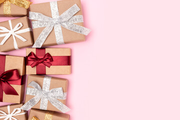Wrapped gifts tied with ribbons on a pink background. Festive concept with place for text.
