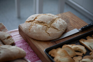 Hogaza de pan sobre tabla de madera con cuchillo. Loaf of bread on wooden board with knife.