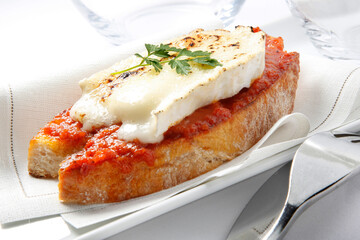 Canapé  de queso  fundido con tomate. Canapé of melted cheese with tomato.