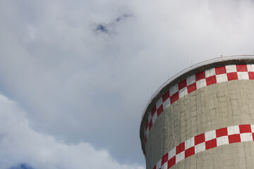 Coal-fired power plant tower blowing white smoke into sky.