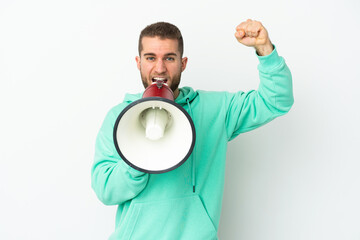 Young handsome caucasian man isolated on white background shouting through a megaphone to announce...