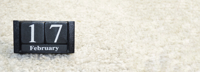 Wooden calendar from blocks on white background with copy space.17th of February