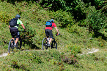 Zwei Mountainbiker beim Downhill auf einem Gebirgs-Trail