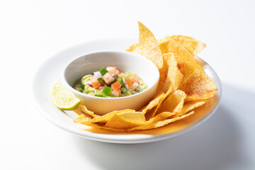Aguacate con nachos sobre fondo blanco, aperitivo. Avocado with nachos on a white background, appetizer.