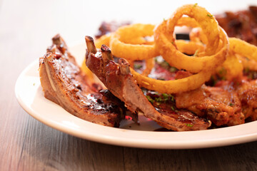 De cerca costillas con aros de cebolla. Close up ribs with onion rings.