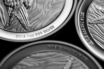 Close up of  Silver Bullion Coin on a black mirror background