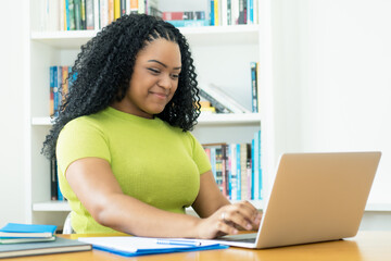Corpulent african american female student learning at computer