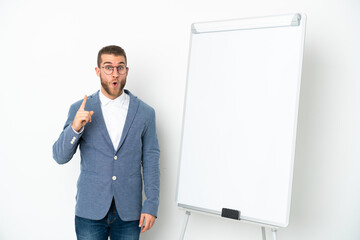 Young business woman giving a presentation on white board isolated on white background intending to realizes the solution while lifting a finger up