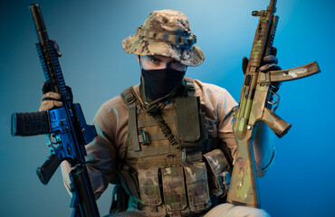 portrait of an evil army soldier in camouflage military clothes with automatic rifles in his hands