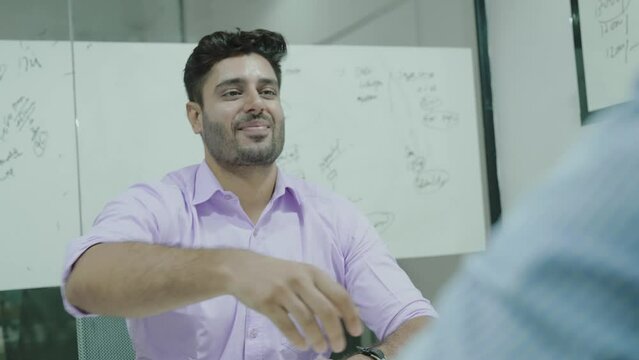 Indian ethnicity confident male applicant passing job interview finish formal appointment shaking hands with male employer. Successful business meeting, making deal, hr, company staffing concept.
