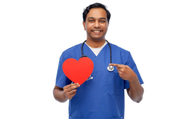 healthcare, profession and medicine concept - happy smiling indian doctor or male nurse in blue uniform with red heart and stethoscope over white background