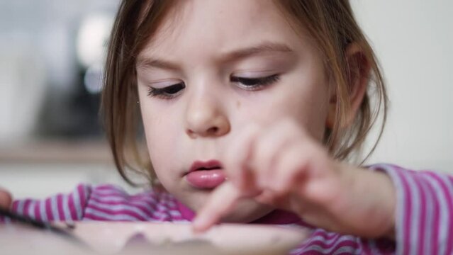 Close up of preschool girl portrait with eating soup at home. picky eater 