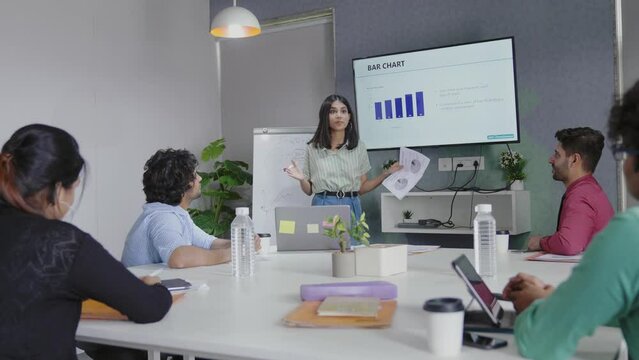 Business presentation Attractive young Indian business woman making presentation to her colleagues in the conference chart room.