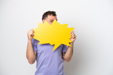 Young Brazilian man isolated on white background holding an empty speech bubble and hiding behind it