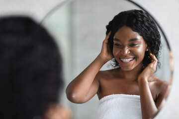 Beautiful african american lady taking care about her curly hair