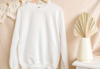 White sweatshirt mockup on a hanger. Blank mockup with boho backgrounds and palm leaf.