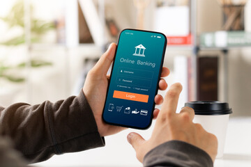 Male executive using smartphone to conduct online mobile banking, investing in stocks and mutual...