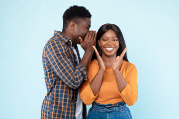 Naklejka premium Black Man Sharing News With Excited Woman Whispering To Ear