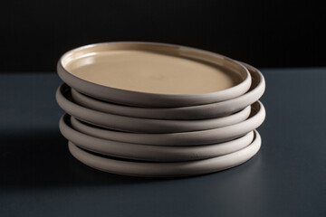 tableware, kitchen utensil and dishes concept - close up of ceramic plates on black table