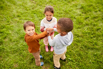 Fototapeta premium childhood, leisure and people concept - group of children playing game at park