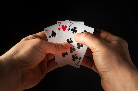 The player hands hold playing cards with a winning combination of three of a kind or set. Success at poker