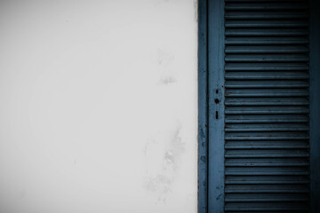 White grunge cement wall and old blue door background.