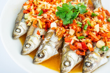 A plate of white fish with chopped peppers
