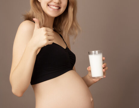 Portrait of a beautiful pregnant woman with glass of milk. Breakfast. The concept of useful diet pregnant. Side view. Pregnant woman drinking milk