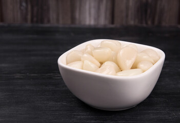 Fototapeta na wymiar Tasty pickled garlic in the bowl. Canned garlic.