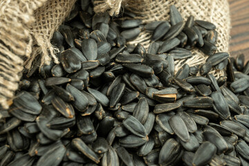 Sunflower seeds are scattered on homespun fabric with a rough texture. close-up, selective focus.