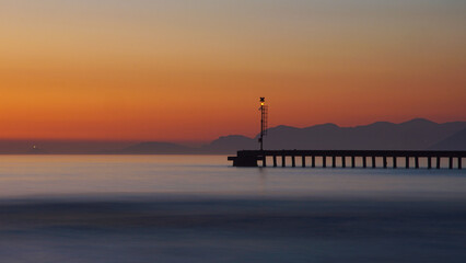 Fototapeta na wymiar pier after the sunset with sky and sea