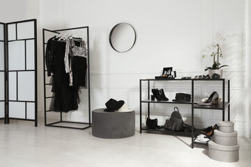 Stylish dressing room interior with trendy clothes, shoes and accessories