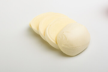 head of mozzarella cheese and cut into slices on a white background