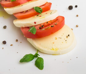 head of mozzarella cheese and red tomato sliced ​​on a white background