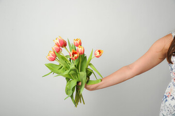 frau hält hand mit blumen blumenstraß tuplen ostern