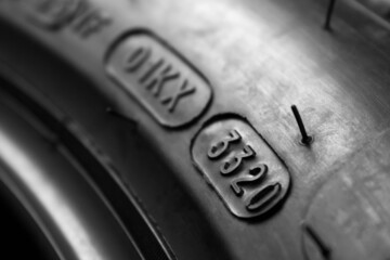 Dot code and date of production of the tire on the sidewall of the wheel. Close up. Tire shelf life