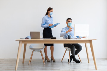 Portrait Of Colleagues In Face Masks Working At Office Together