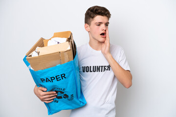 Teenager Russian man holding a recycling bag full of paper to recycle isolated on white background shouting with mouth wide open to the side