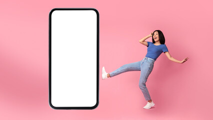 Fototapeta na wymiar Korean Woman Posing Near Big Smartphone Screen Over Pink Background
