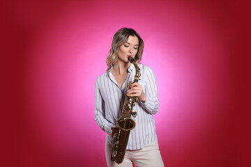 Fototapeta na wymiar Beautiful young woman playing saxophone on red background