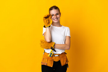 Young electrician woman isolated on yellow background with glasses and happy